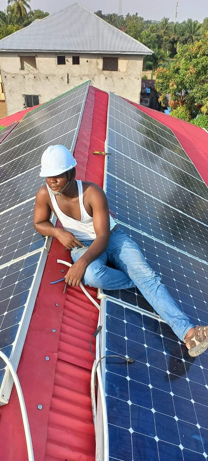 Technician installing solar panels on a rooftop in Liberia