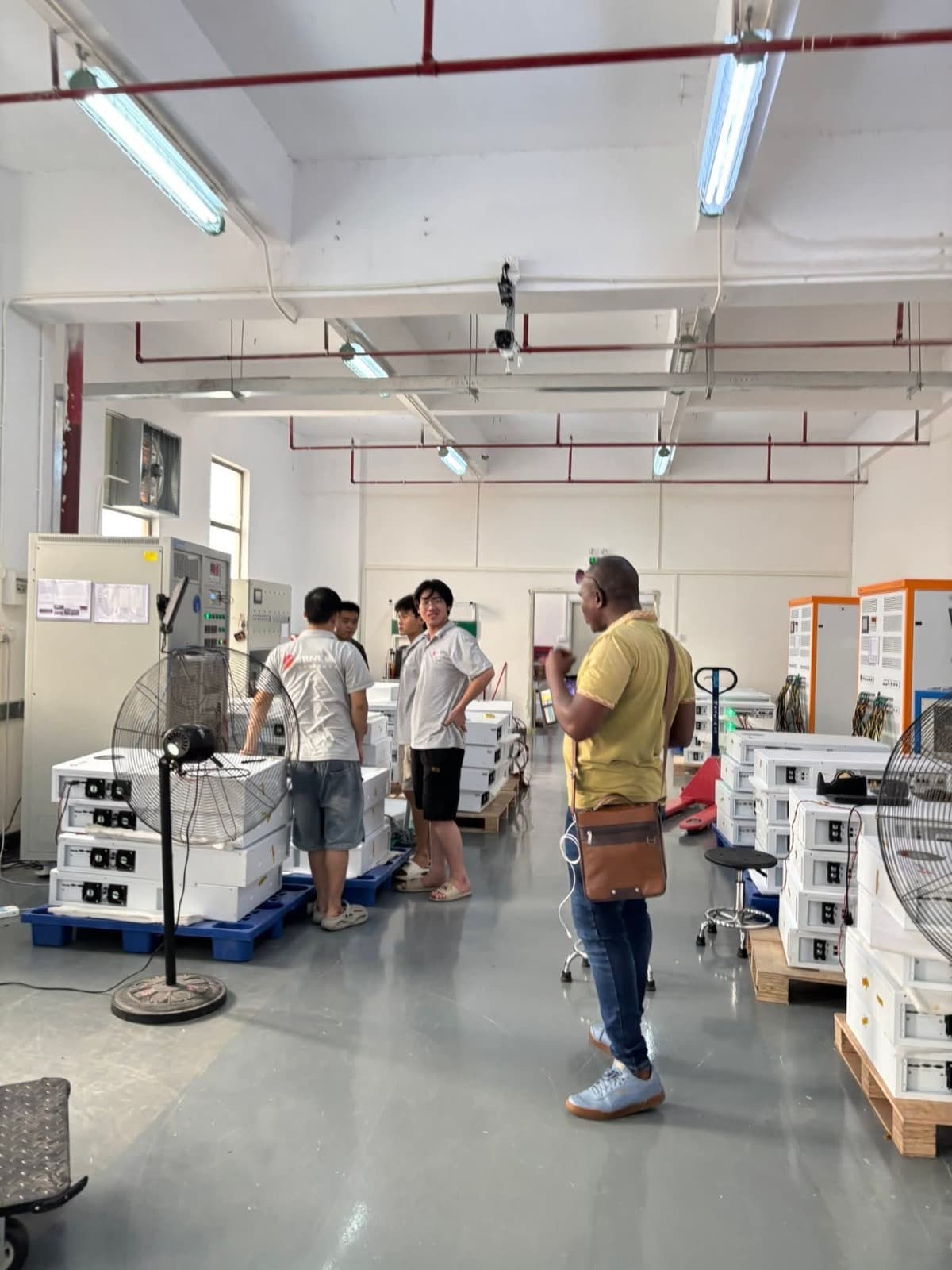 Team members reviewing solar battery equipment in a warehouse facility