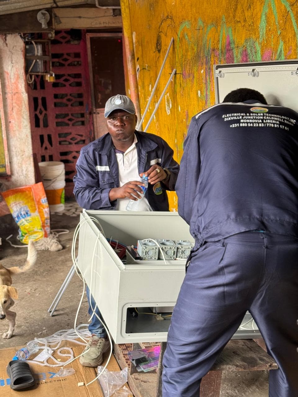 Solar technicians wiring an electrical control enclosure on site
